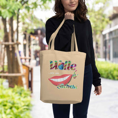 Eine Frau kommt vom Einkaufen und zeigt stolz ihre austern-farbige Shopper Tasche aus Bio Baumwolle mit dem Aufdruck: Wolle ist wie ein lächeln